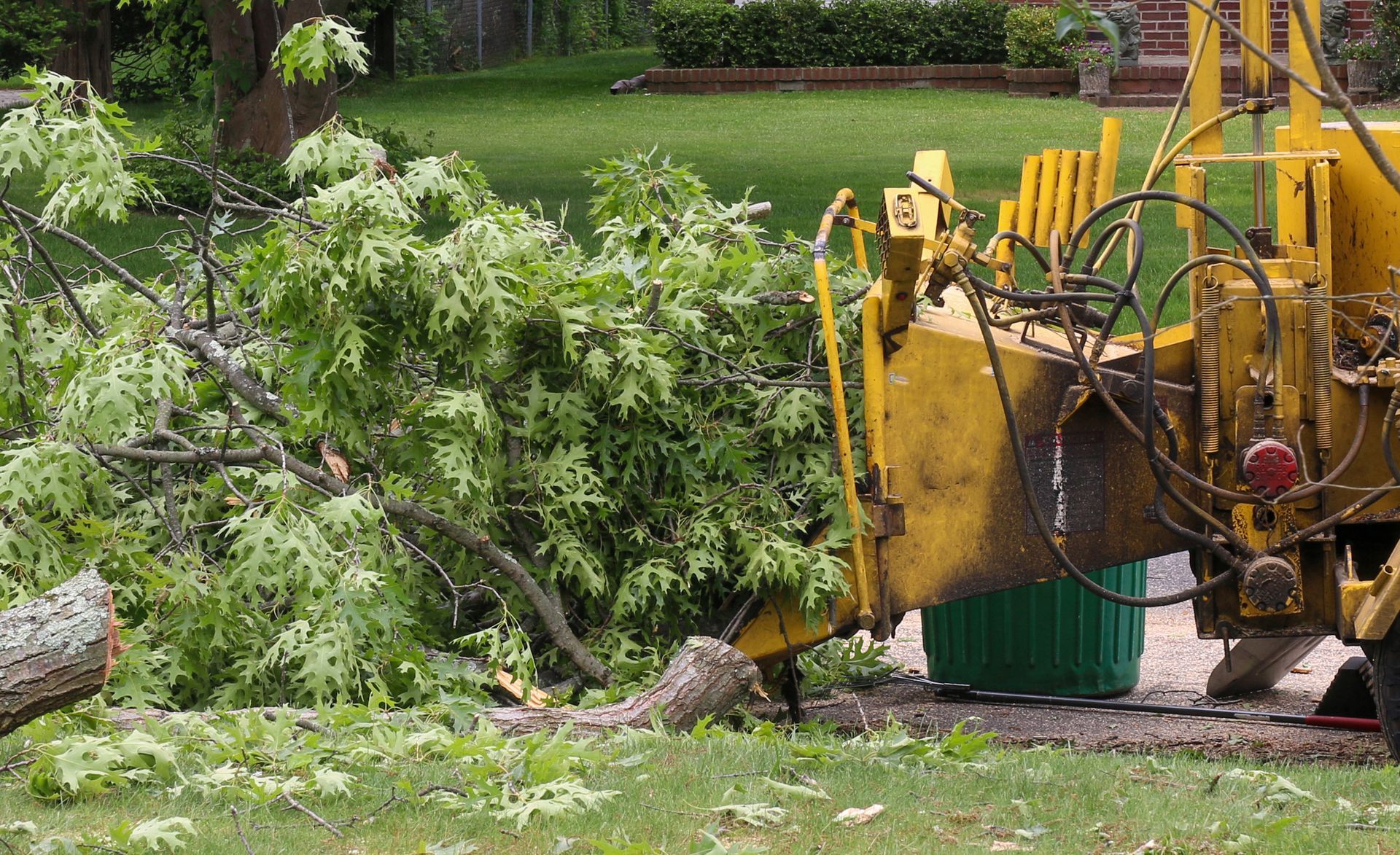 A tree stump is being removed by a machine in a yard.