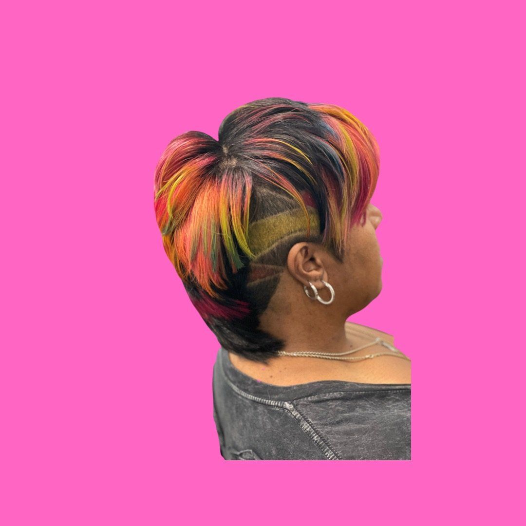 A woman with short hair and a shaved head is wearing earrings.