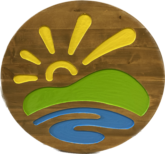 A wooden circle with a sun and a river on it