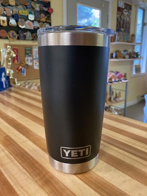 A black yeti tumbler sitting on a wooden table