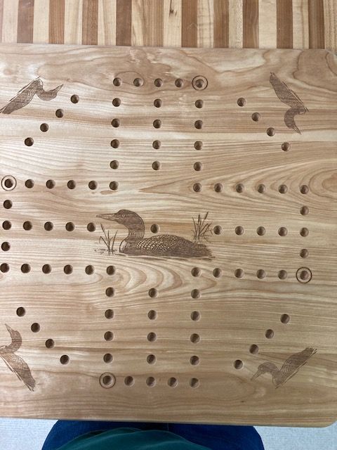 A wooden board with holes in it and a picture of a duck on it.