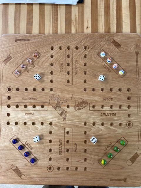 A wooden board game with dice on it is sitting on a wooden table.