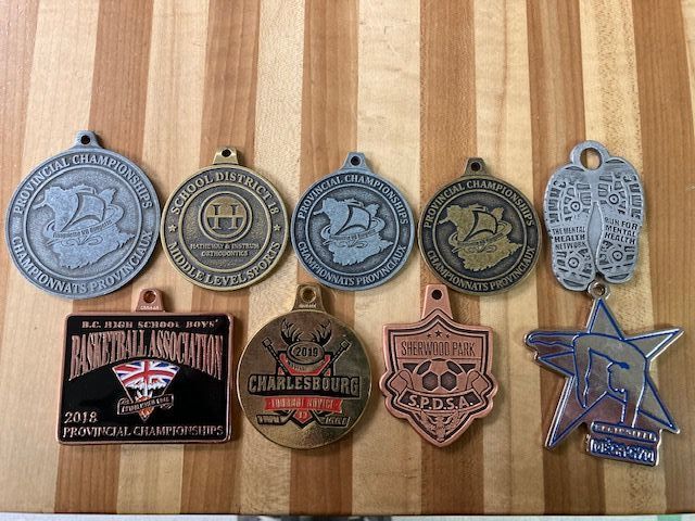 A bunch of medals are sitting on a wooden table