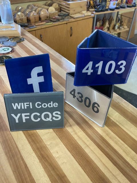 Two signs on a table that say wifi code yfcqs