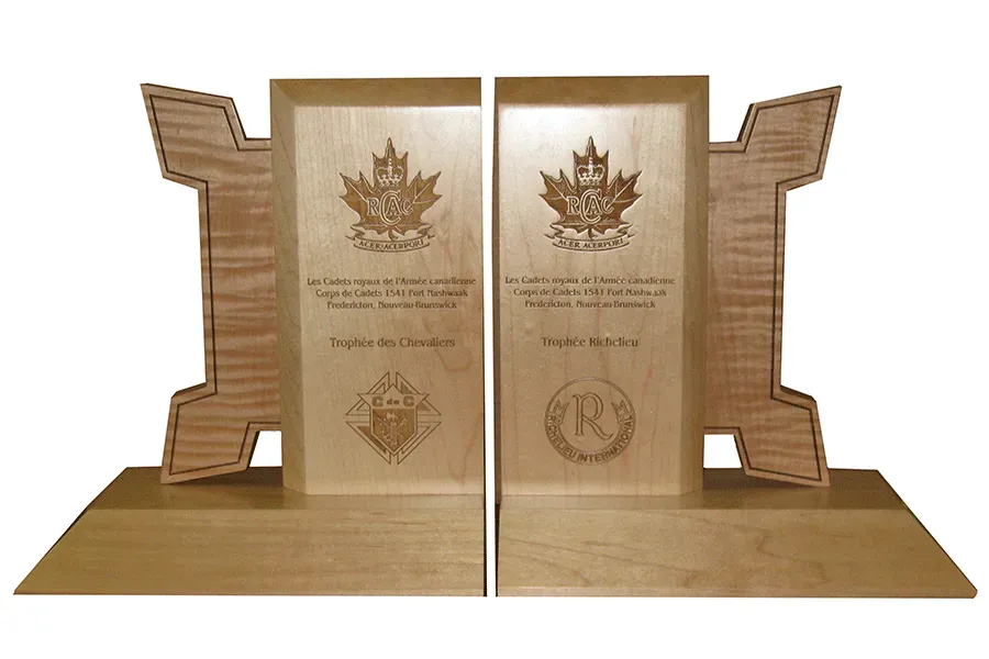 A pair of wooden bookends with a maple leaf on them