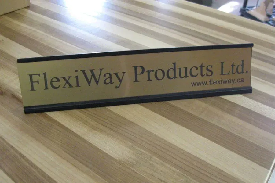 A name plate for flexiway products ltd. sits on a wooden table