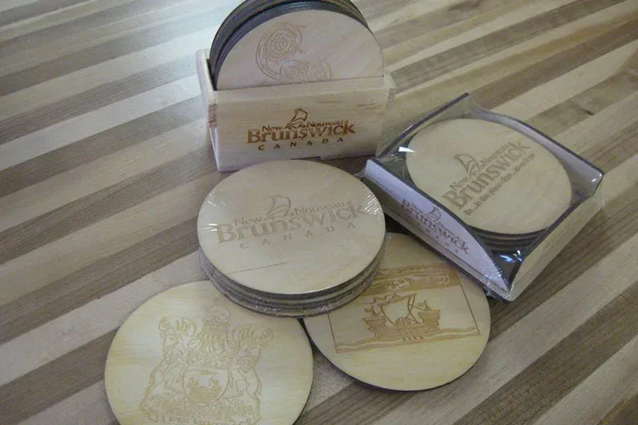 A stack of wooden coasters sitting on top of a wooden table.