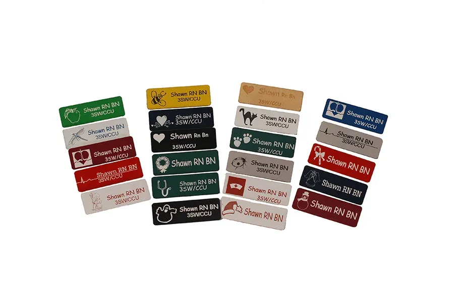 A bunch of name tags are sitting on top of each other on a white surface.