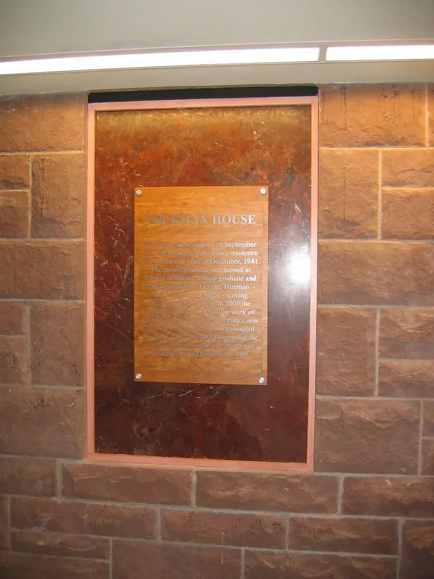 A plaque on a brick wall that says ' george washington ' on it