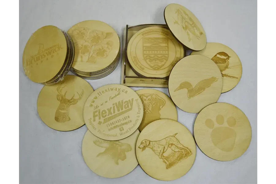 A bunch of wooden coasters with different designs on them