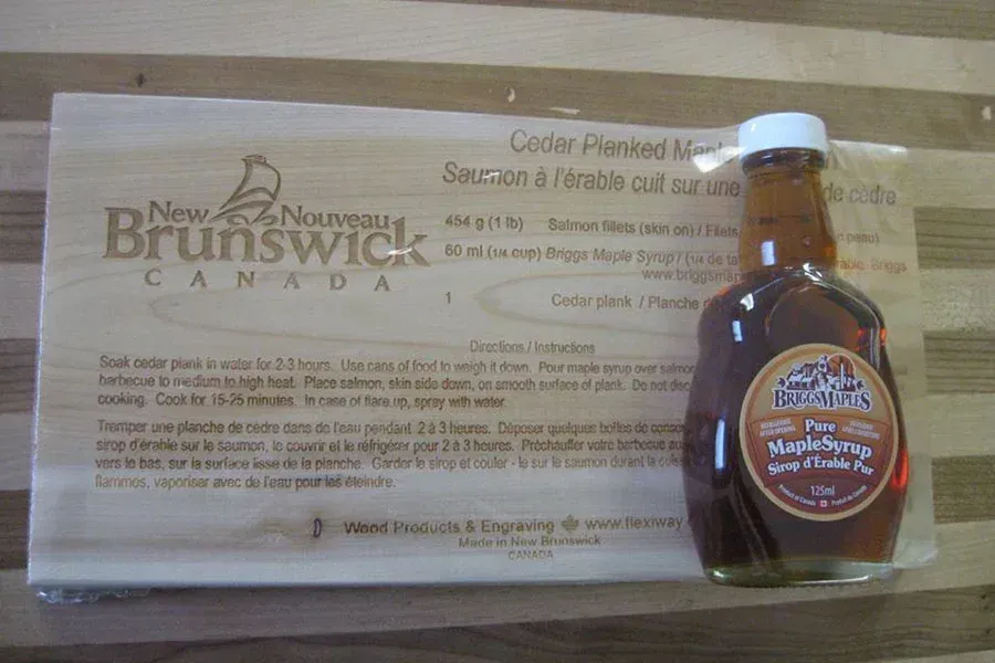 A bottle of maple syrup sits next to a new brunswick canada sign