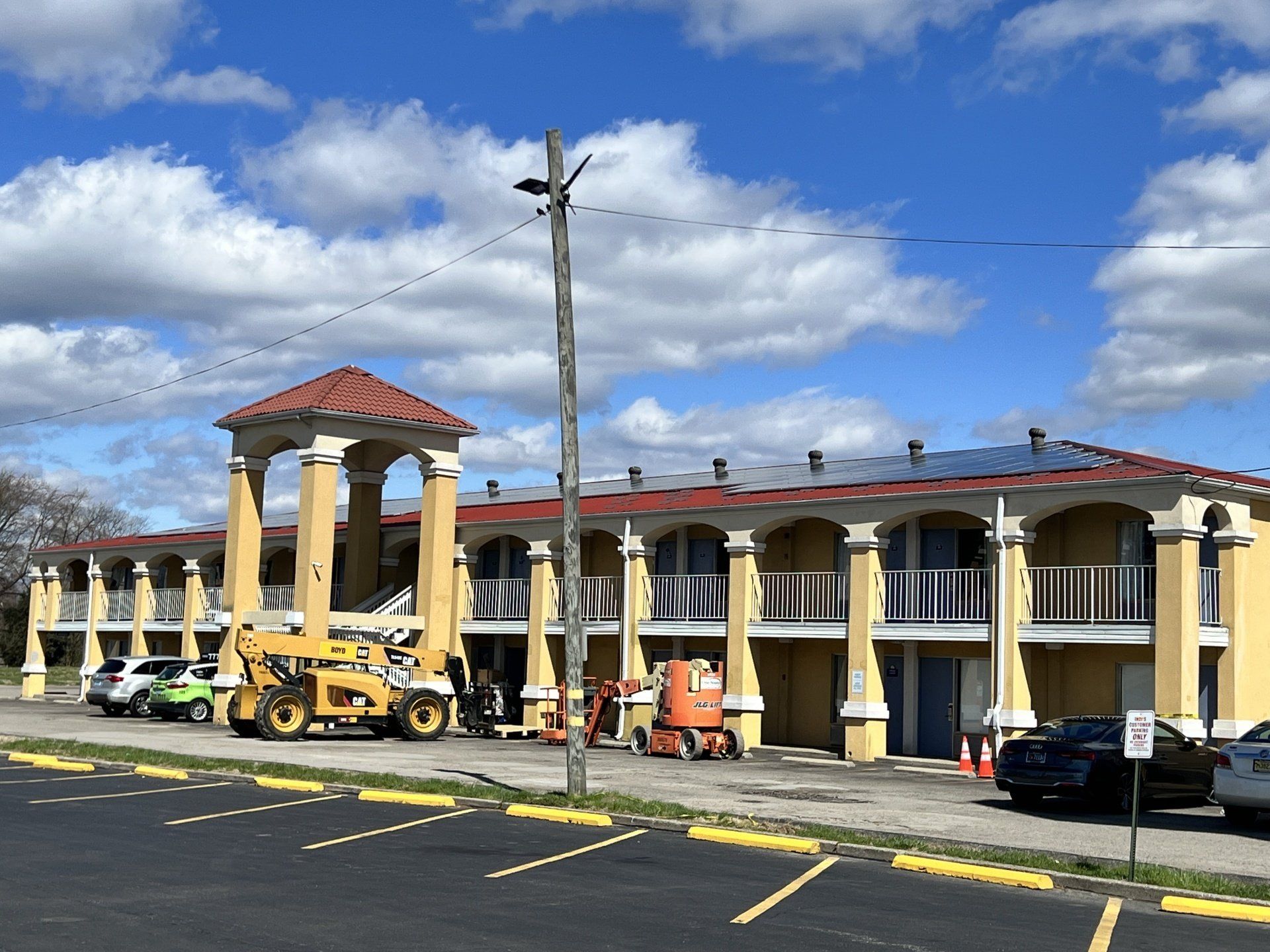 A large yellow building with a red roof is under construction