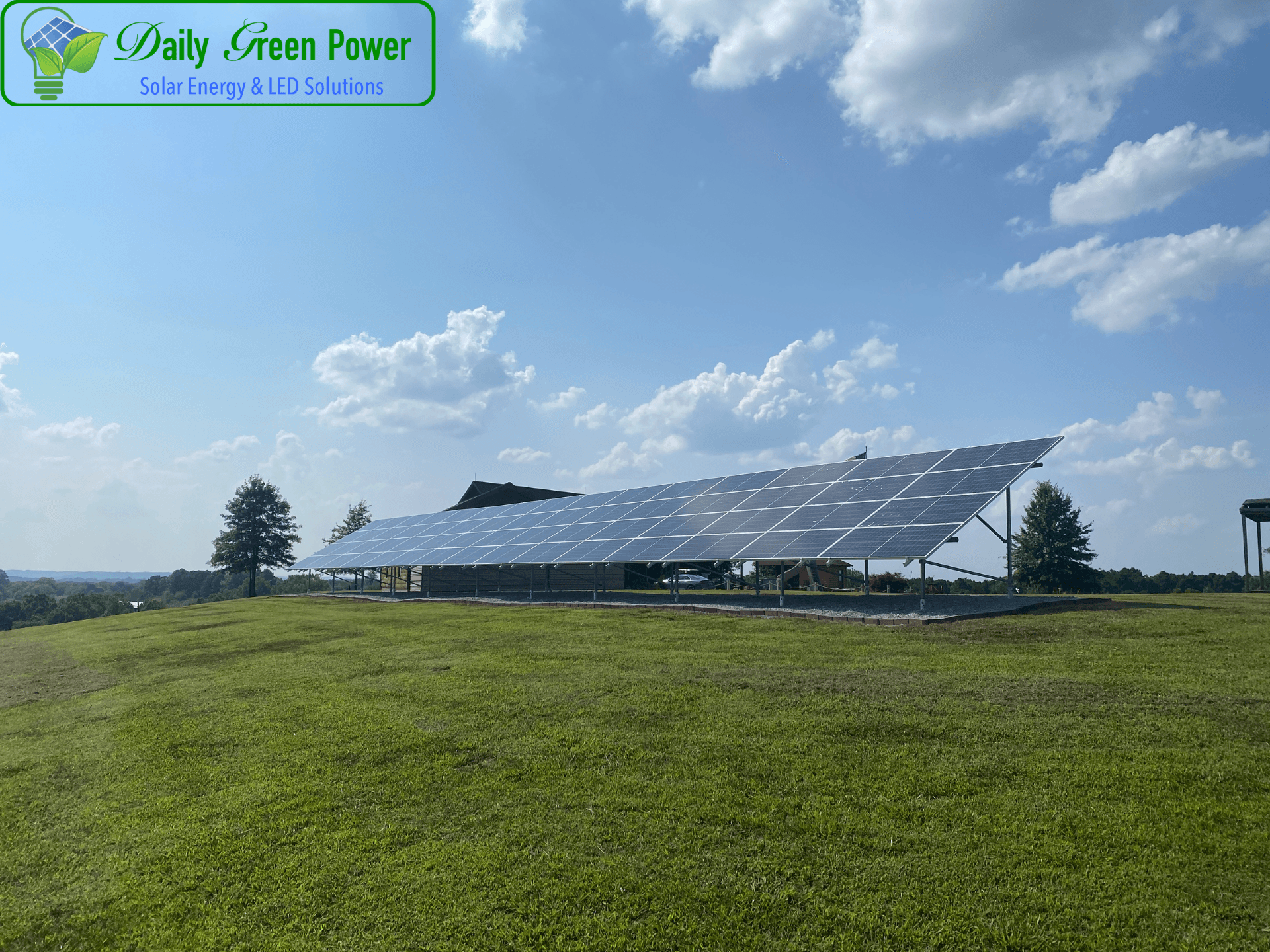 A row of solar panels sitting on top of a lush green field.