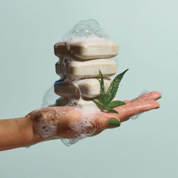 A person is holding a stack of soap bars in their hand.