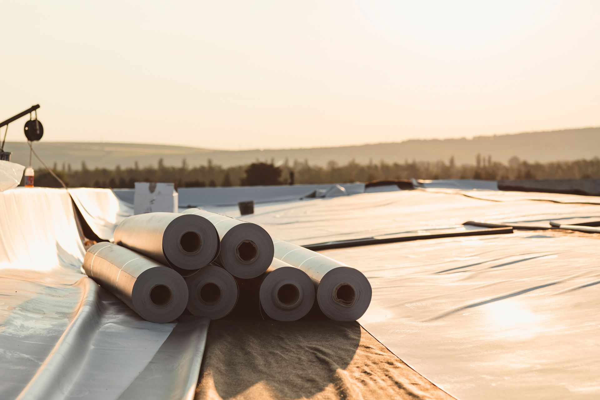 A stack of rolls of roofing material sitting on top of a roof.