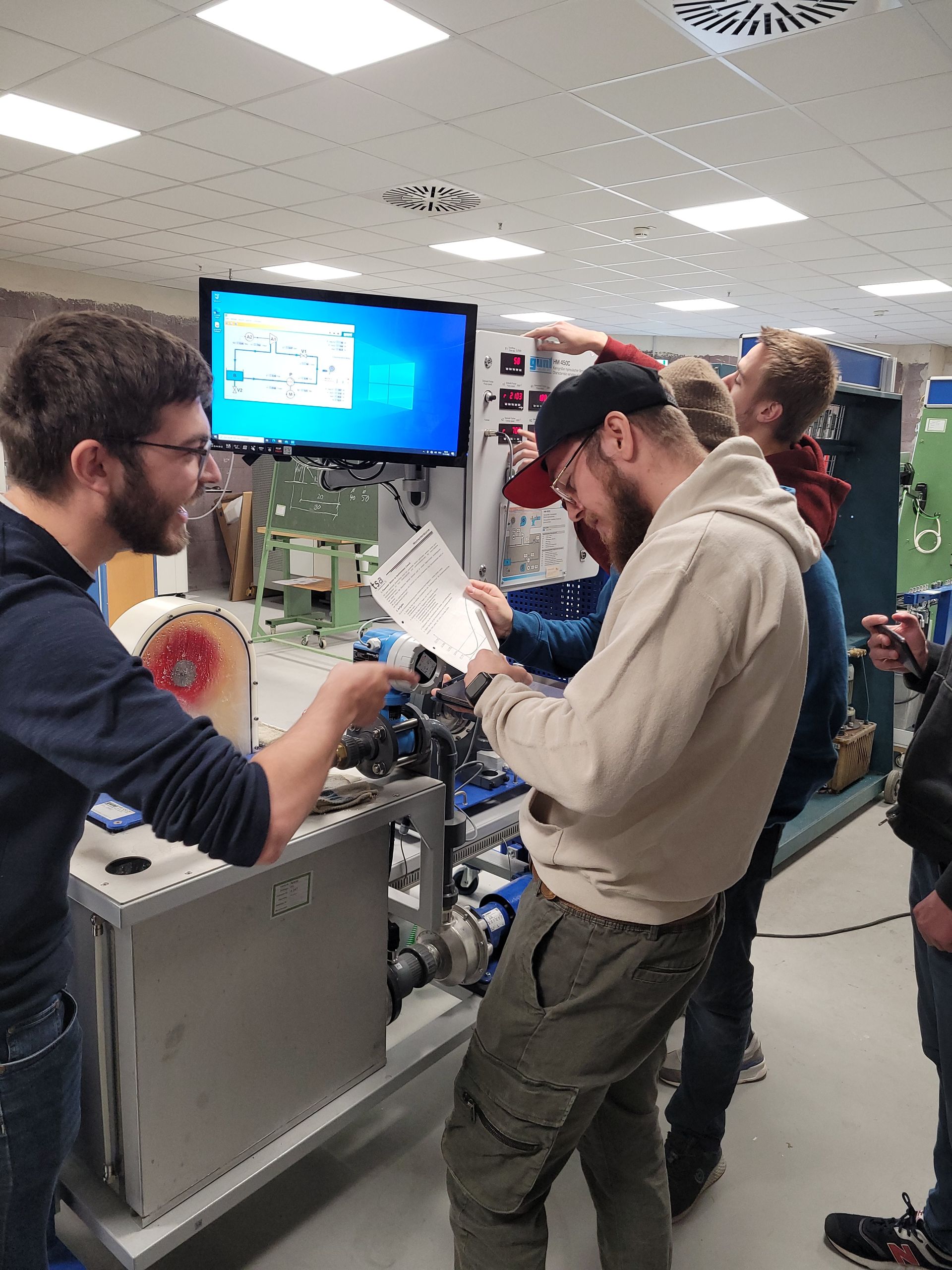 Ein Mann und eine Frau stehen in einer Bibliothek und schauen auf ein Blatt Papier.