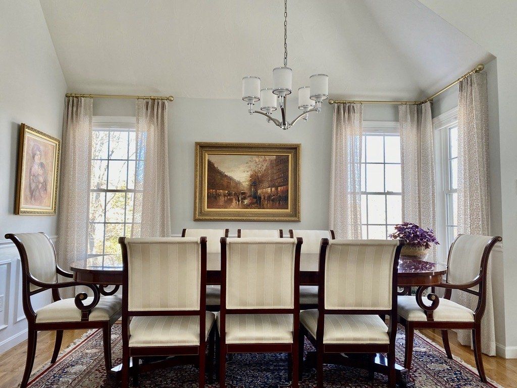 a dining room with a table and chairs and a chandelier Simply Windows.