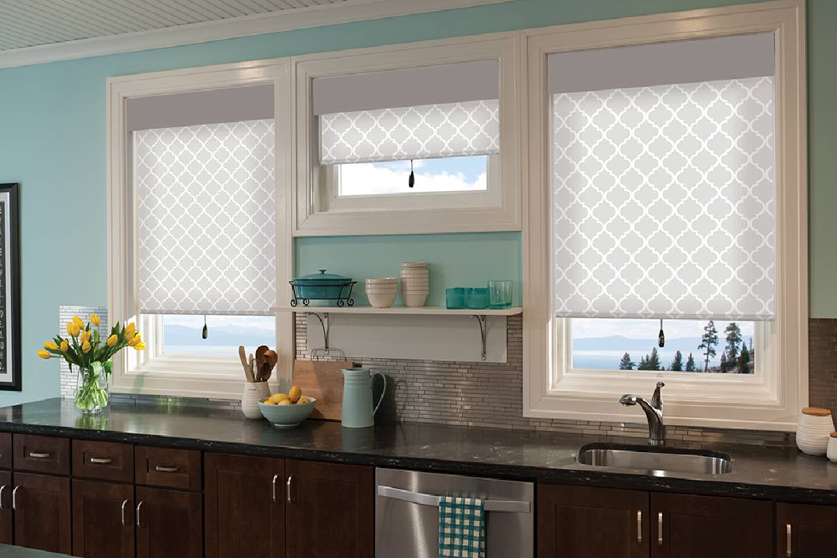 a kitchen with a sink , dishwasher , and three windows with roller shades  Simply Windows.