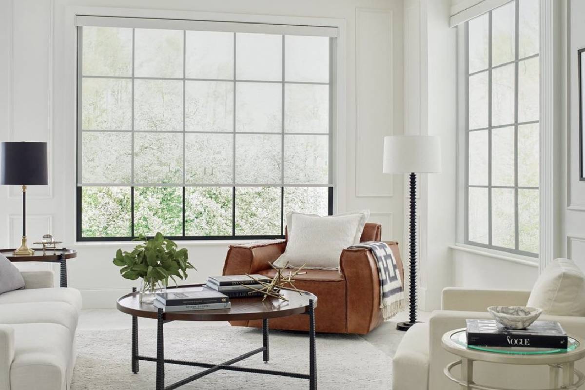 a living room with a couch , chair , table and window wit roller shades Simply Windows.