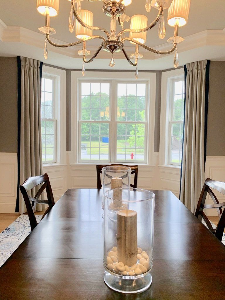 a dining room table with a vase of candles on it Simply Windows.