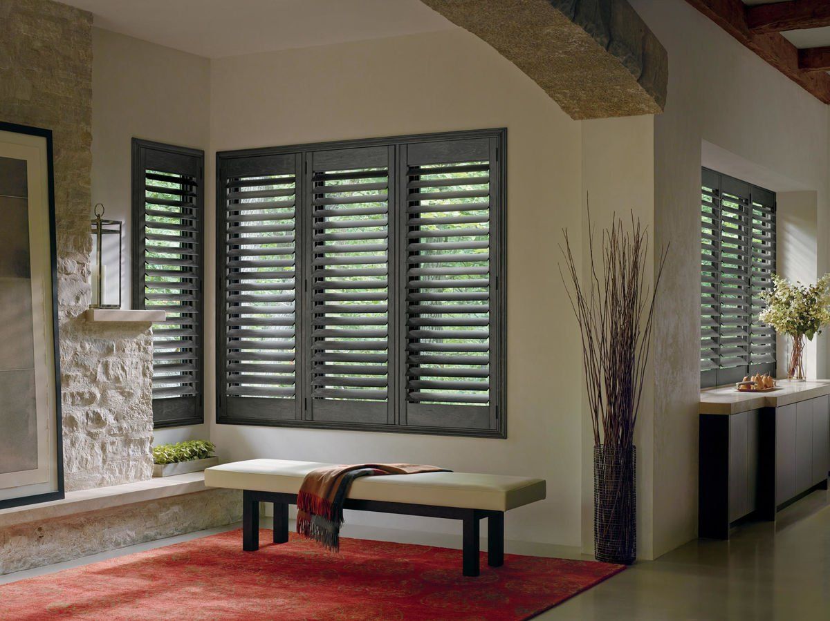 a living room with a bench in front of a window with shutters Simply Windows.