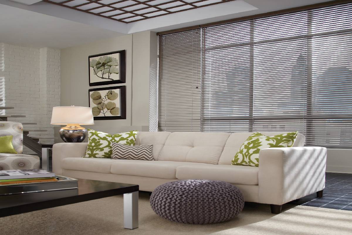a living room with a couch and a coffee table and metal blinds on the windows Simply Windows
