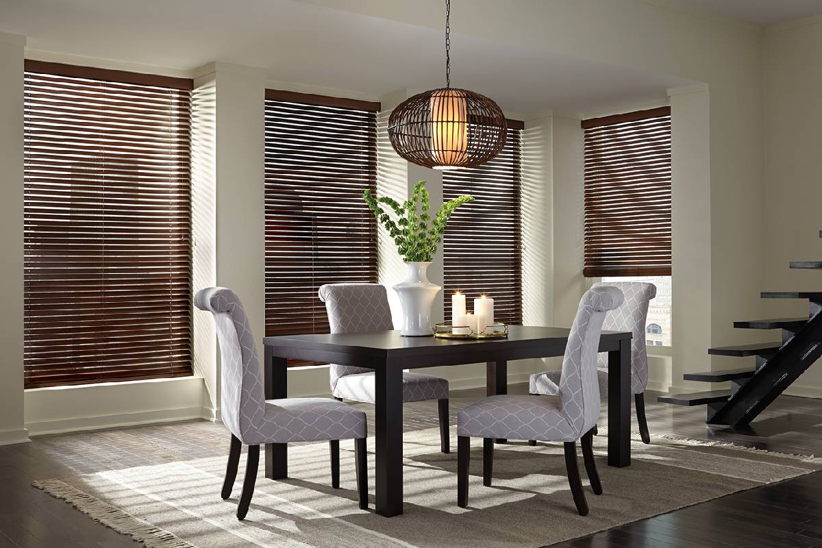 a dining room with a table and chairs and wood blinds Simply Windows