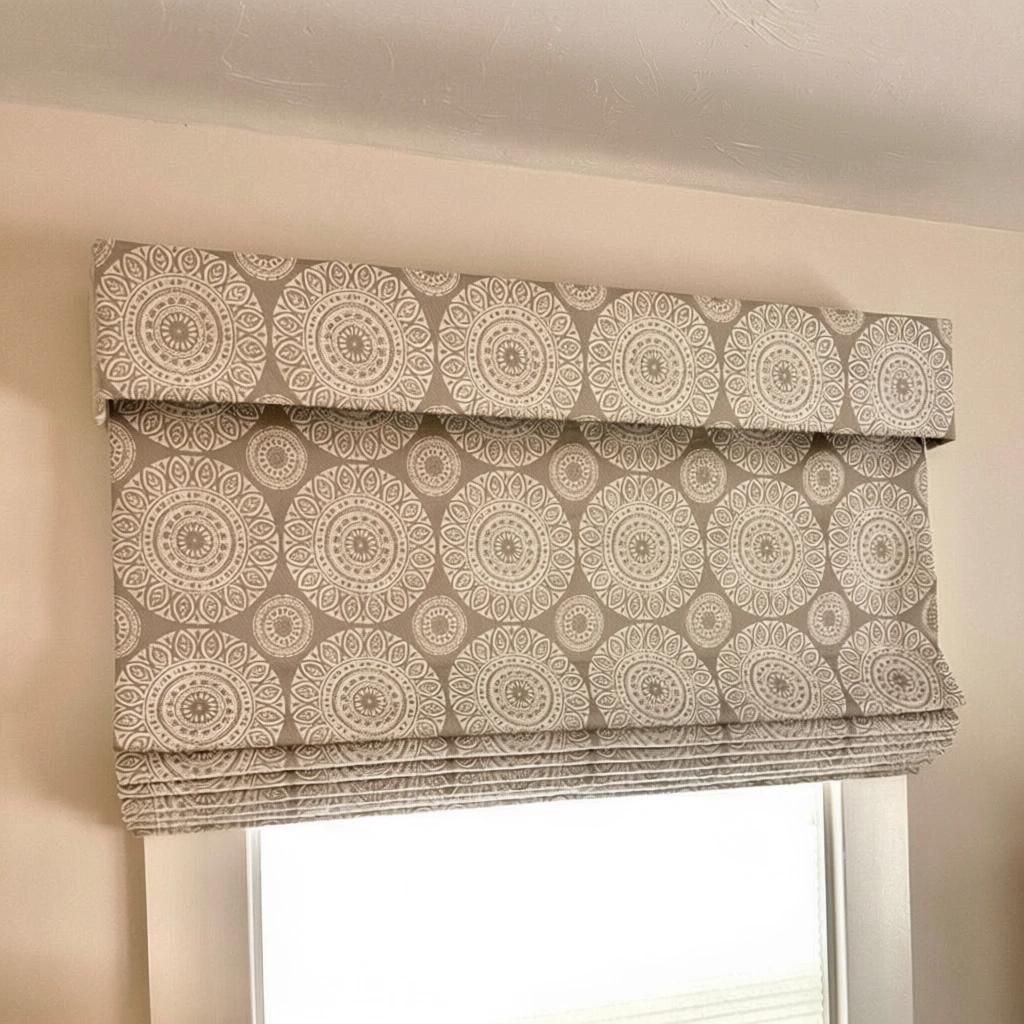 Roman shade with a circular patterned fabric covering a window.