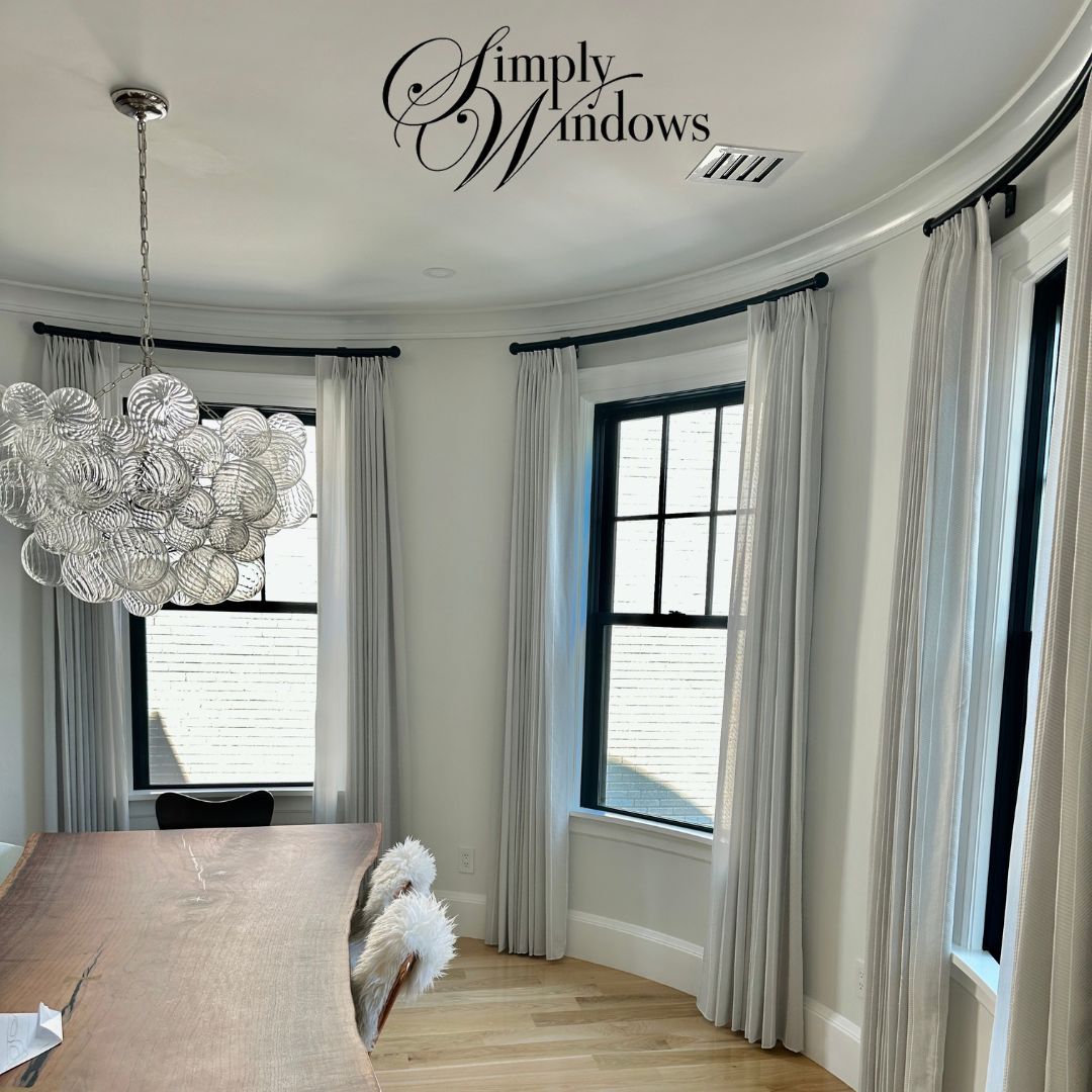 A curved dining room has elegant custom hardware for the custom drapery - simply windows ma