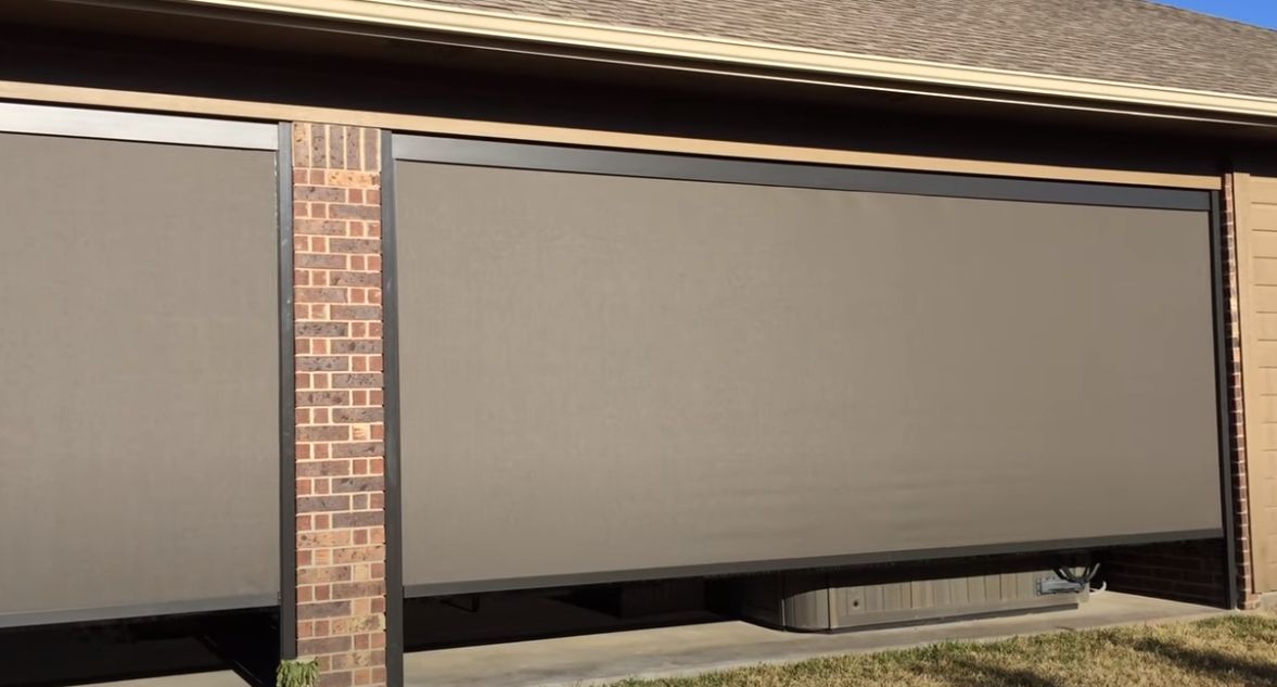a garage door with an exterior patio shades on it and a brick wall Simply Windows.