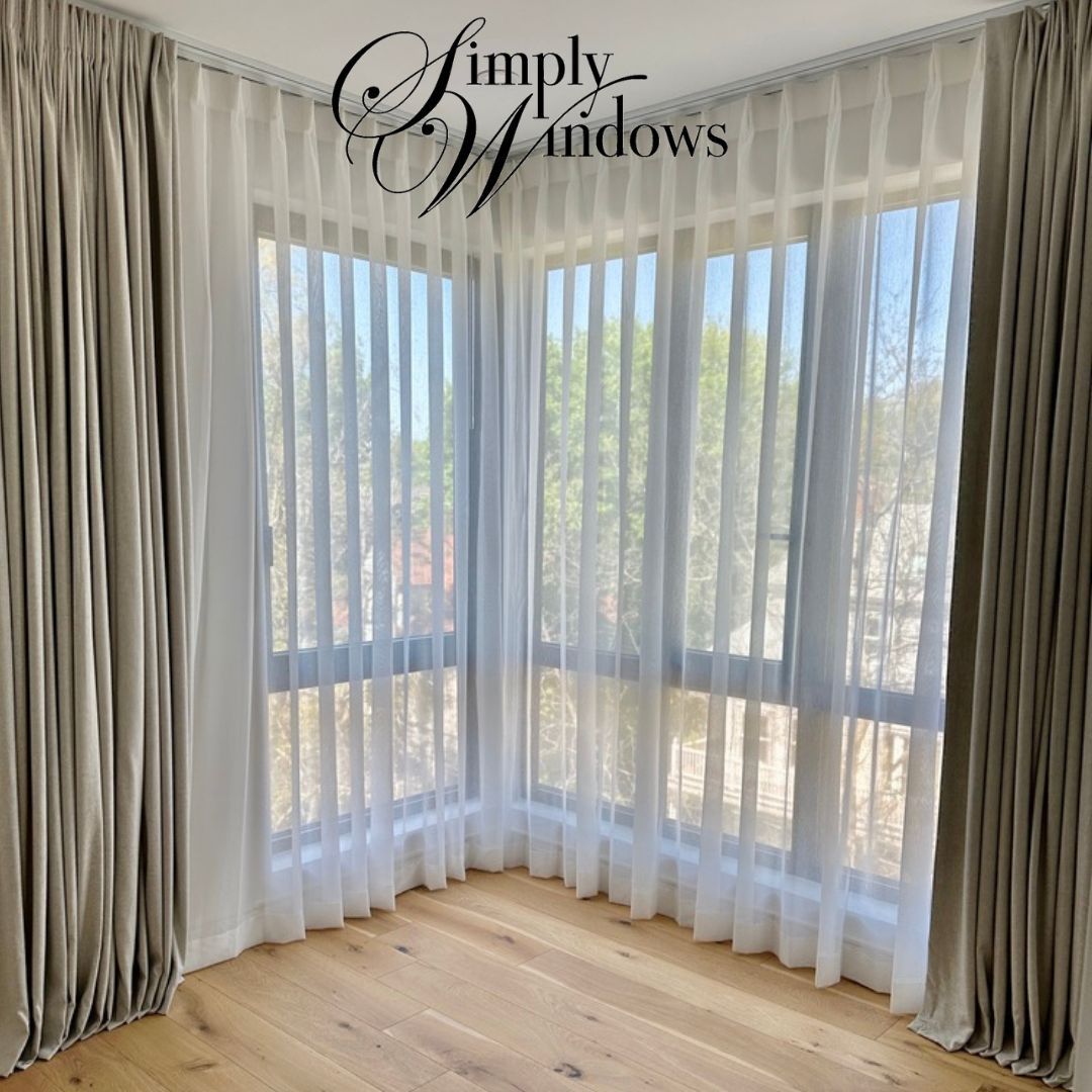 A large corner window has custom drapery and sheers for a unique window solution - simply windows, ma