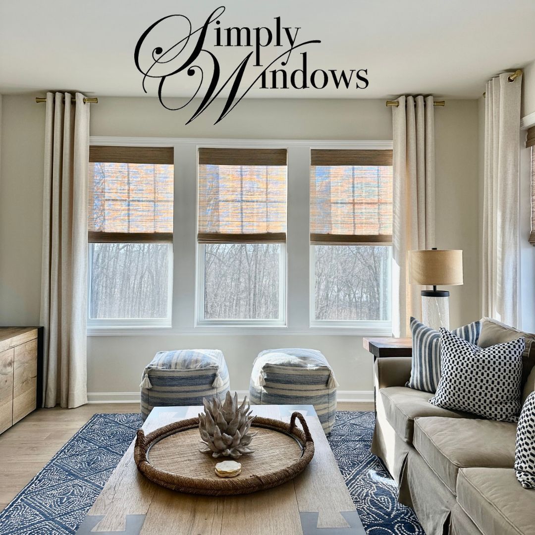 A comfortable living room has layered window treatments on the windows - simply windows, ma