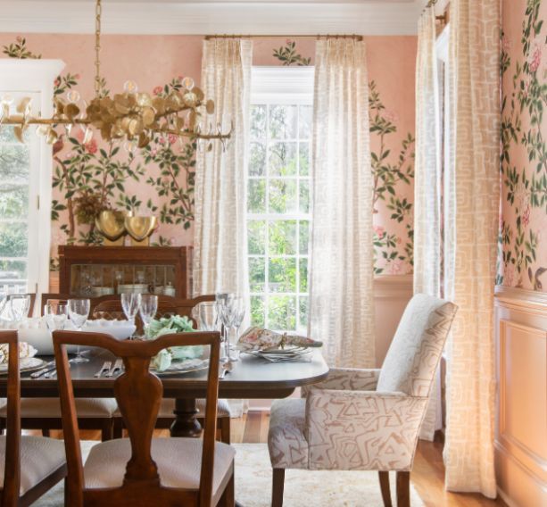 An elegant pink dining room with floral wallpaper and Thibaut fabrics for drapes. 