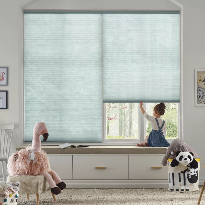 Simply Windows: A little girl is looking out of a window, under blue cordless automated shades.