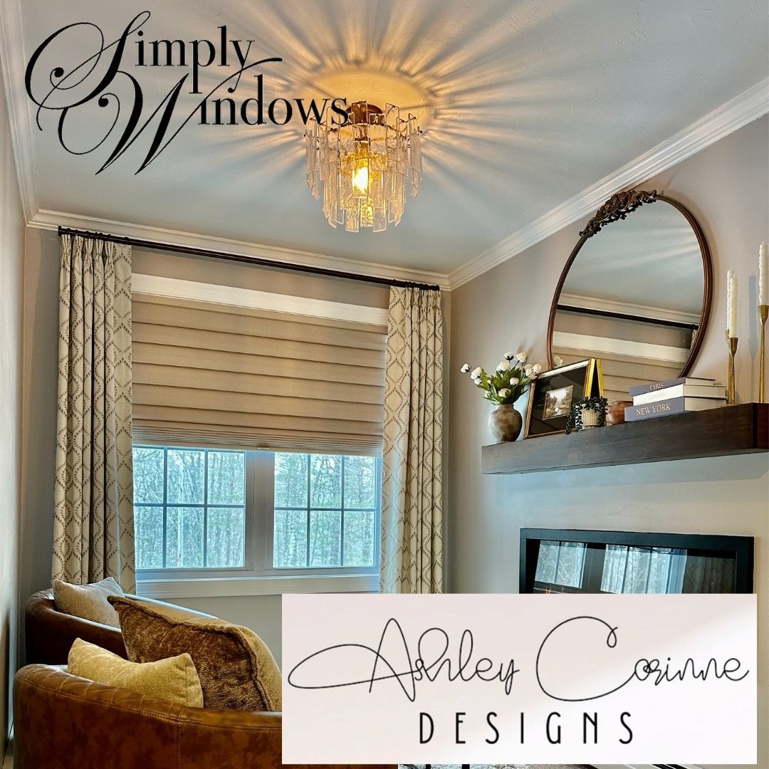 A room featuring floor-to-ceiling patterned curtains, tan Roman shades, a crystal flush-mount light, and a mantel mirror.