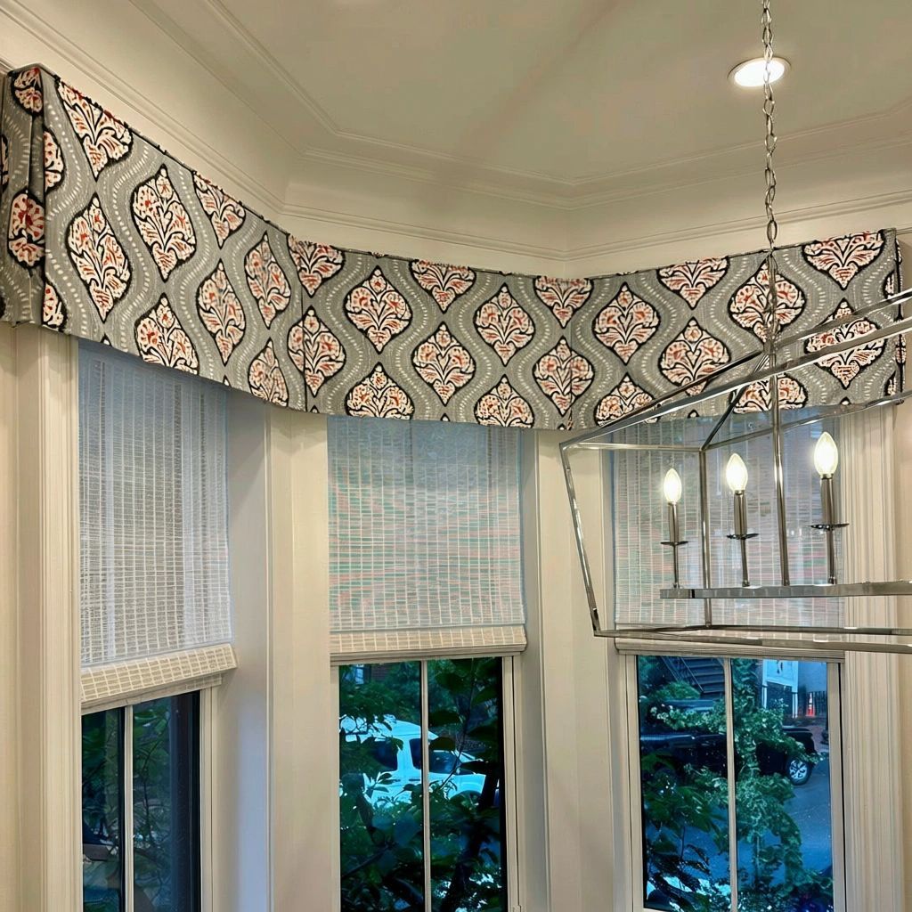 A bay window in a dining room has a custom valance and roman shades - simply windows
