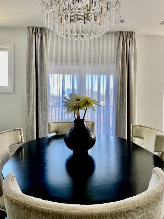Simply Windows: There is a vase of flowers on the table in the dining room, and a window with custom drapes.