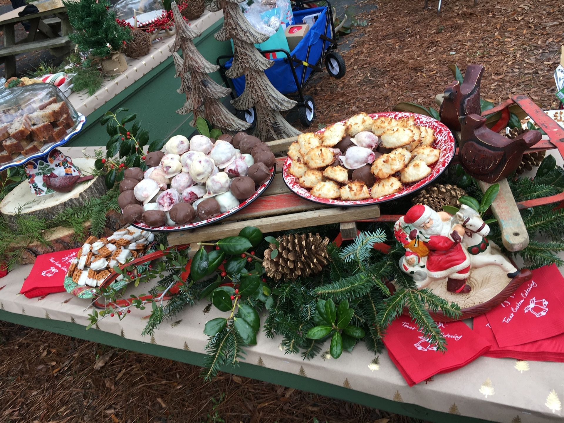Outdoor holiday display with Christmas cookies, greenery, candy canes, and festive decorations on a table