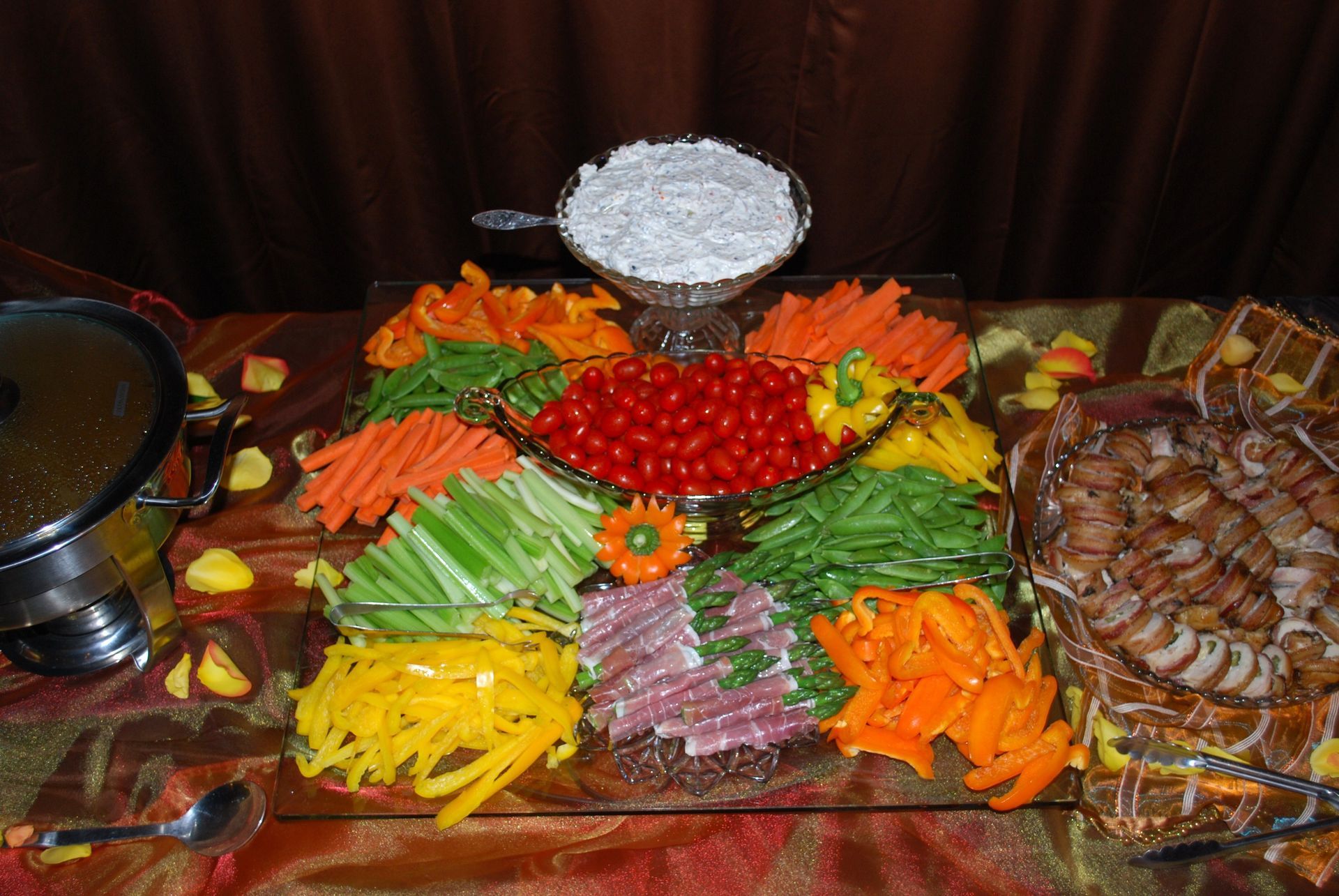 Colorful buffet of assorted fresh vegetables arranged in a decorative display with bowls of dip