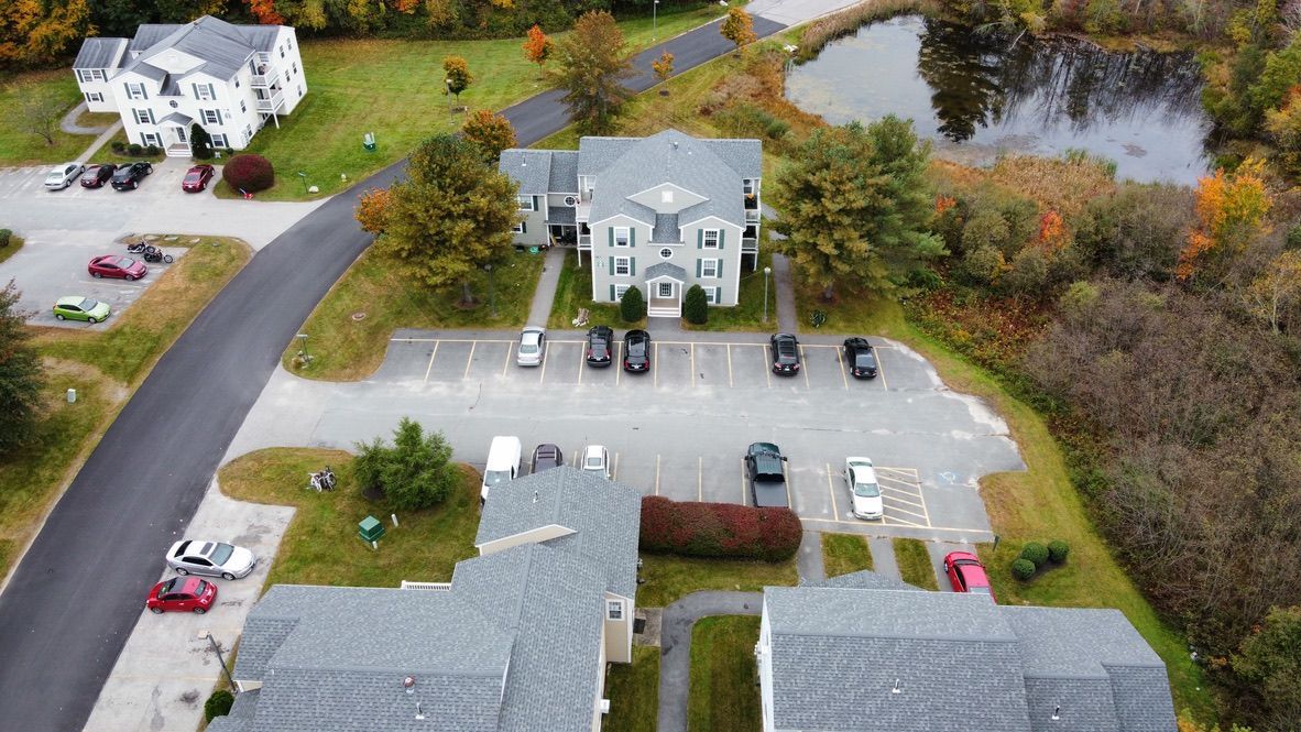 an aerial view of a residential area with houses and a parking lot .