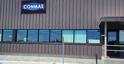 Conmas building with a sign on the side.