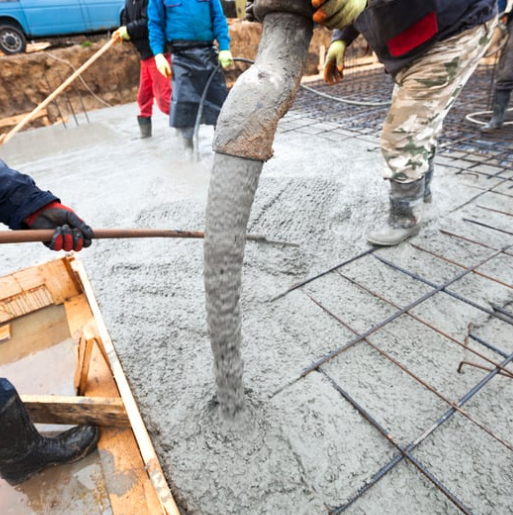 Concrete building supplies being used to pour reinforced concrete foundation.