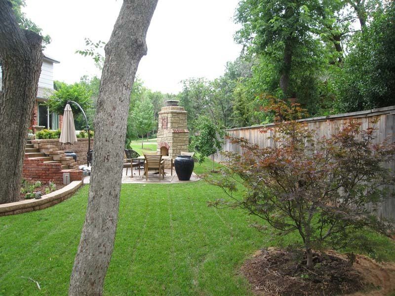 A backyard with a fireplace and a patio area