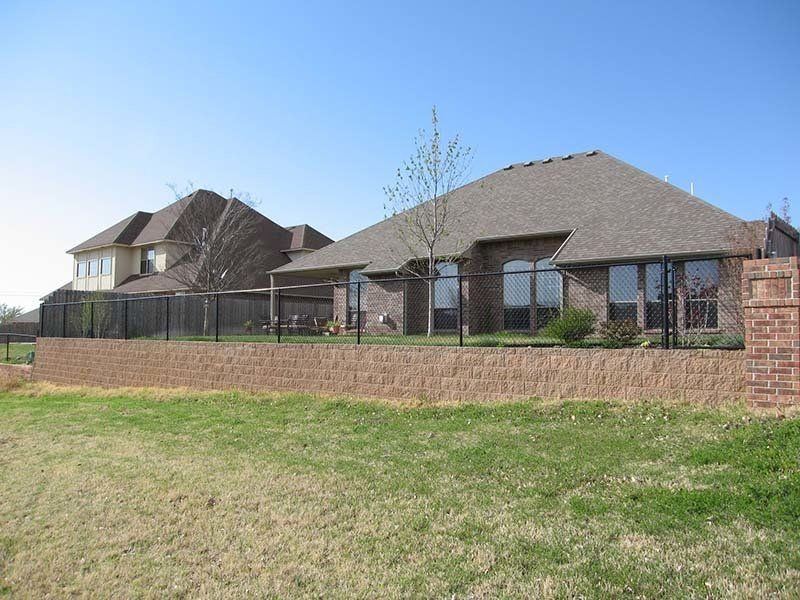 A large brick house with a fence around it