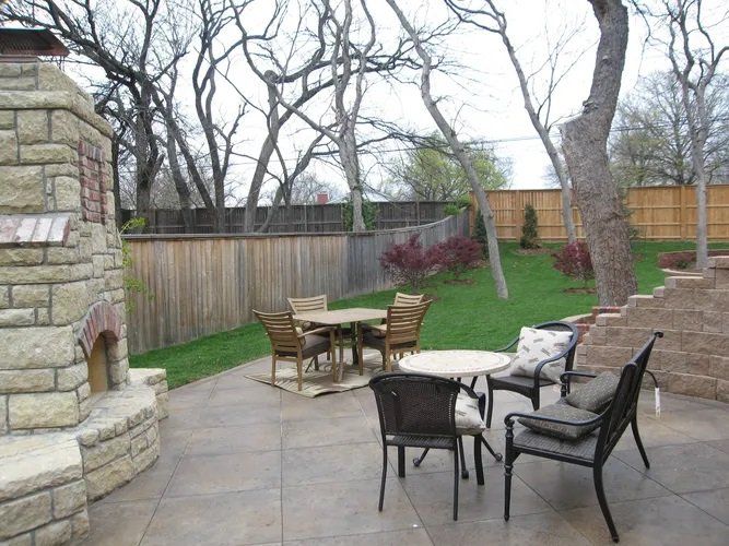 A patio with a table and chairs and a fireplace