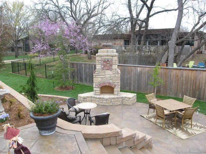 A patio with a fireplace and tables and chairs
