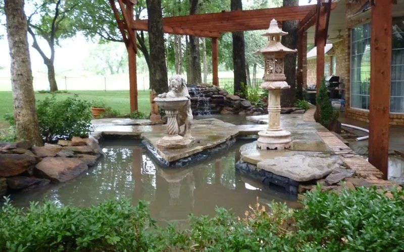 A pond with a lantern in the middle of it