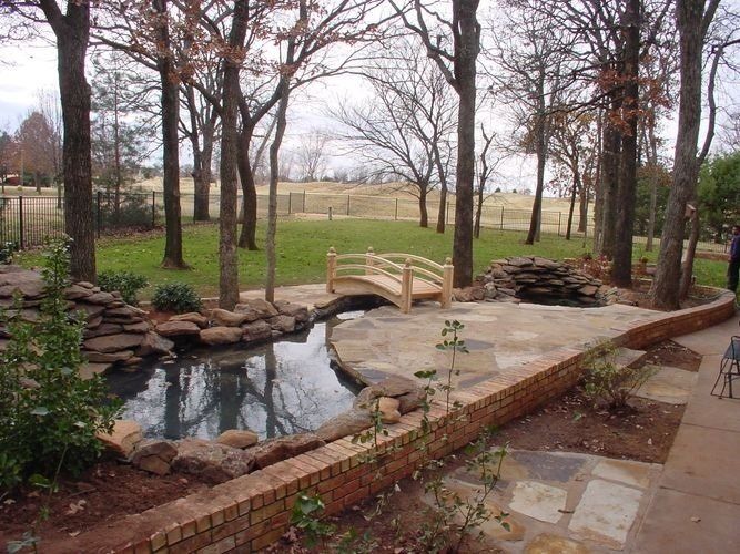 A wooden bridge over a pond in a garden