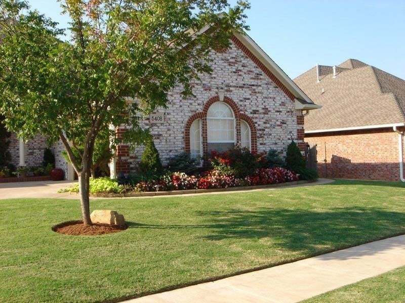 A brick house with a tree in front of it