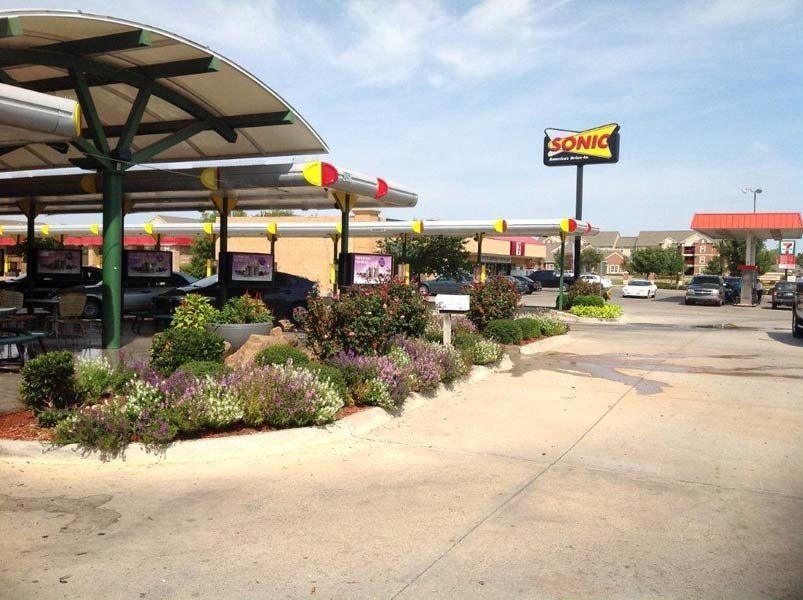 A Sonic restaurant with a lot of cars parked in front of it